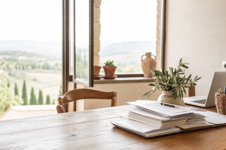 Fogli stampati impilati su un piano di lavoro, pronti per il conteggio dei costi.